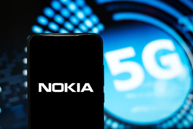 Baksidan på en svart mobiltelefon med texten Nokia i vitt och en 5G illustration i bakgrunden.