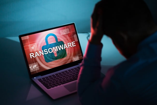 Orolig man tittar på krypterad dator som blivit utsatt för ransomwareattack.